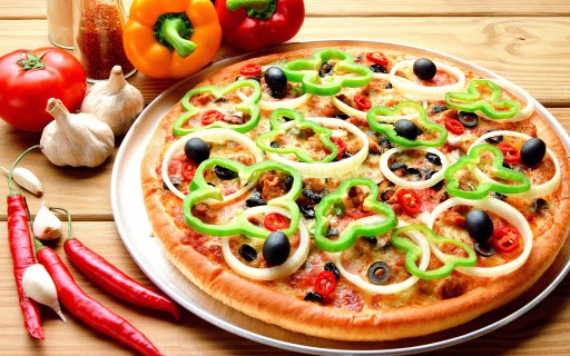 Pizza on metal dish and vegetable